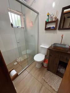 a bathroom with a toilet and a glass shower at Pousada Espírito Santo - Estamos ubicados a solo 100 metros de la Ruta BR-290 in São Gabriel