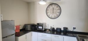 a kitchen with a counter with a clock on the wall at Sea 'n Summit Suite in Hermanus