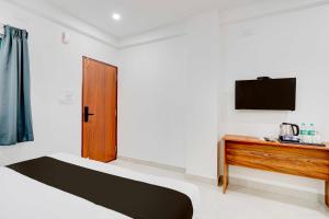 une chambre avec un lit et une télévision au mur dans l'établissement Townhouse Bangalore Kundalahalli Metro Station, à Bangalore 22 autres photos