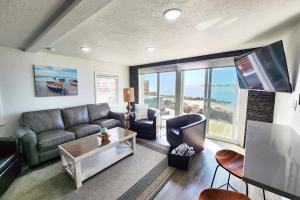 ein Wohnzimmer mit Sofa und Tisch in der Unterkunft Alsea Bay Cottage with Hot Tub! The Retreat in Waldport