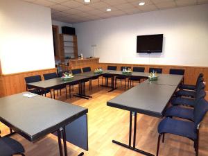 a conference room with tables and chairs and a flat screen tv at Hotel Hammermühle in Stadtroda +91 photos