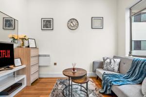 a living room with a couch and a table at The Cosy Luxe in Slough