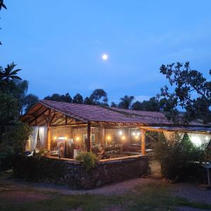 - un pavillon en bois éclairé la nuit dans l'établissement Pousada Suçuarana, à Itabirito