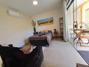 a bedroom with a bed and a couch in a room at Recanto Tucuns-Guest House in Búzios