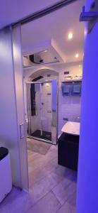 a bathroom with a walk in shower and a sink at Costantinopoli Suite in Giovinazzo