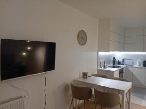 un salon avec une table et une télévision sur un mur dans l'établissement Koliber, à Ustrzyki Dolne 9 autres photos