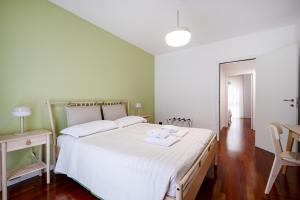 a bedroom with a large bed with white sheets at Casa Diletta— Bright Spaces, Warm Moments in Stazione Bari Centrale