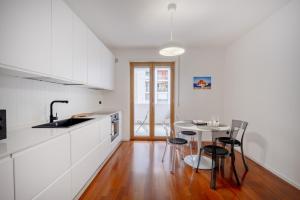 a kitchen with white cabinets and a table with chairs at Casa Diletta— Bright Spaces, Warm Moments in Stazione Bari Centrale