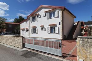 a white house with a fence in front of it at Apartments Miljenka in Nin