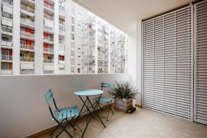 a table and chairs in a room with tall buildings at Casa Diletta— Bright Spaces, Warm Moments in Stazione Bari Centrale