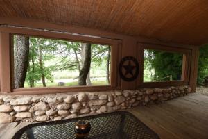 a porch with two windows and a stone wall at Jones Riverside Cabin in Utopia