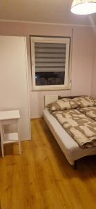 a bedroom with a bed and a table and a window at Nocleg Jakubskie Przedmieście in Toruń