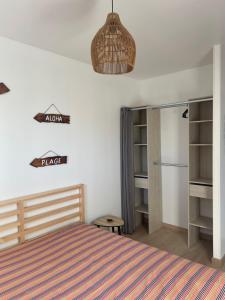 a bedroom with a bed with a striped blanket at Magnifique maison neuve Mimizan plage proche océan in Mimizan-Plage