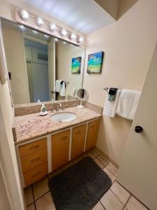 een badkamer met een wastafel en een grote spiegel bij Lahaina Shores #316 in Lahaina