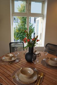 Una mesa con platos y vasos y un jarrón con flores. en A Place To Stay Stavanger, apartment 5 - Decorated for Christmas, en Stavanger 41 fotos más