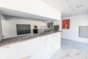 a lobby with a counter with a tv on a wall at Hotel Nogalera in Torremolinos