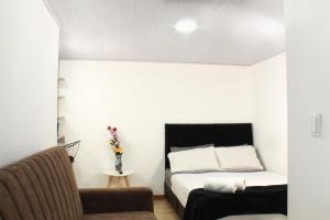 a bedroom with a bed and a chair at Garden's Aparta hotel in Bogotá