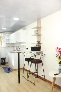 a kitchen with a counter and two stools in a room at Garden's Aparta hotel in Bogotá