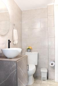 a bathroom with a white toilet and a sink at Garden's Aparta hotel in Bogotá