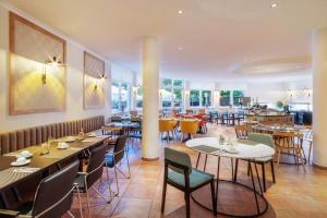 une salle à manger avec des tables et des chaises dans un restaurant dans l'établissement Hotel Bochum Wattenscheid affiliated by Meliá, à Bochum