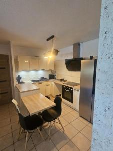 モンペリエにあるLogement entier F4のテーブルと椅子と冷蔵庫のあるキッチン