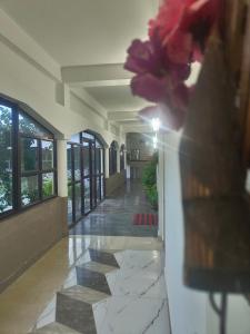 a hallway of a building with a vase of flowers at Saagar's Farmstay in Jalpāiguri