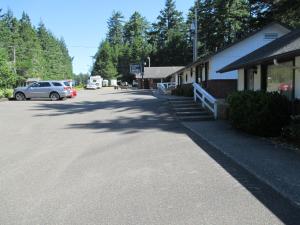 Woahink Lake Suites في Dunes City: شارع فيه سيارة متوقفة بجانب مبنى