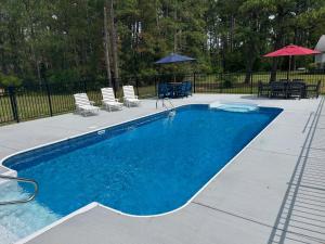 MadisonにあるOyster Havenの庭園内のスイミングプール(椅子、パラソル付)