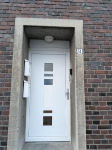 a white door in a brick building with a sign at Voll eingerichtete Wohnung in Geilenkirchen in Geilenkirchen