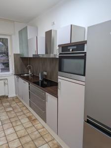 a kitchen with stainless steel appliances and white cabinets at Voll eingerichtete Wohnung in Geilenkirchen in Geilenkirchen