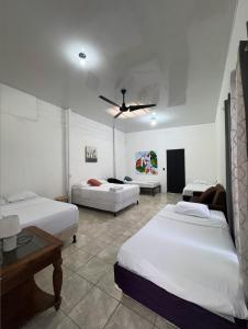 a bedroom with three beds and a ceiling fan at Casa Pelíkano Uvita in Uvita