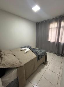 a bedroom with a bed and a window at Apartamento Central in Montes Claros