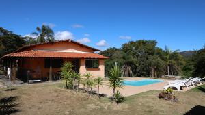 a house with a swimming pool next to a resort at Canto das Árvores - Nova União MG in União de Caeté