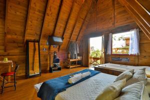 a bedroom with a bed in a room with a tub at Pousada Chalé Suiço Bombinhas in Bombinhas