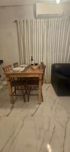 a wooden table with a bottle of wine and a couch at Pousada Coisa Nossa - Praia Cibratel II - 200m da praia in Itanhaém +28 photos