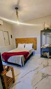 a bedroom with a bed in a room with marble floors at Pousada Coisa Nossa in Itanhaém