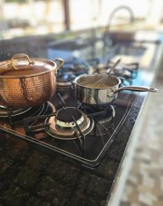 two pots and pans sitting on top of a stove at Refúgio Romântico com Pet Friendly 38min de ÁGUAS CLARAS BRASÍLIA in Brasilia