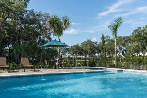 a swimming pool with chairs and an umbrella at Hyatt Place Sarasota/Lakewood Ranch in Sarasota