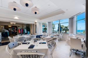 een restaurant met witte tafels, stoelen en ramen bij Portofino V 2005 by Gulf Coast Getaways in Oriole Beach