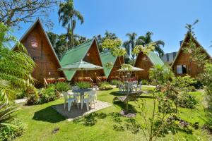 a resort with a table and chairs in the yard at Chalé Suiço Bombinhas in Bombinhas