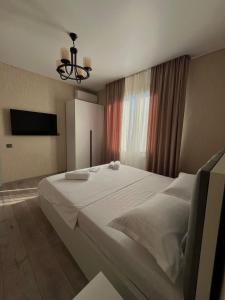 een slaapkamer met een groot wit bed en een televisie bij Lucky Houseee in Grigoleti +11 foto's