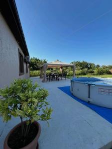 een terras met een zwembad, een tafel en een prieel bij Lucky Houseee in Grigoleti