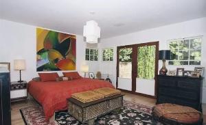 een slaapkamer met een rood bed en een schilderij aan de muur bij Tranquil 3 Bedroom Home in Santa Monica Canyon in Los Angeles +7 foto's