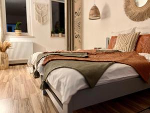 a bedroom with a bed in a room with wooden floors at Apartament Olszowka 12 Bielsko - Biała in Bielsko-Biała