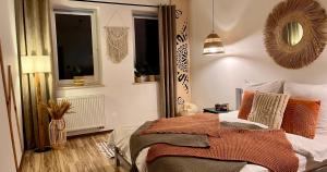 a bedroom with a bed with orange pillows and a mirror at Apartament Olszowka 12 Bielsko - Biała in Bielsko-Biała