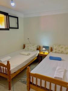 a bedroom with two beds and a table with a lamp at Seaview apartment in Mirleft +25 photos