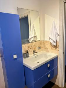 a bathroom with a blue sink and a mirror at Luino Family Retreat in Luino