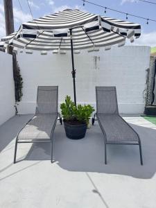 zwei Stühle und ein Sonnenschirm auf einer Terrasse in der Unterkunft AGA House Vacation Rental in Carolina