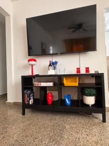 ein schwarzes Entertainment-Center mit einem Flachbild-TV an der Wand in der Unterkunft AGA House Vacation Rental in Carolina