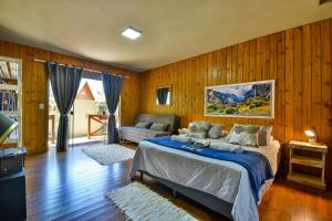 a bedroom with a bed and a couch in it at Pousada Chalé Suiço Bombinhas in Bombinhas